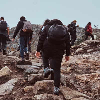 Group of hikers with backpacks, tracking in the mountains.